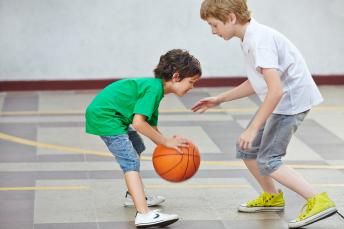 Zwei Jungs spielen zusammen Basketball