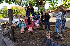 Kinder hängen kopfüber am Klettergerüst