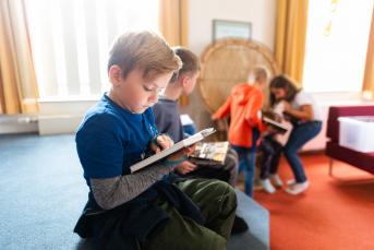 Junge liest in einem Buch im Leseland