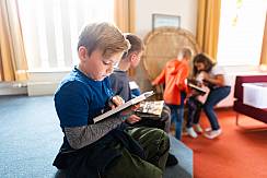 Junge liest in einem Buch im Leseland