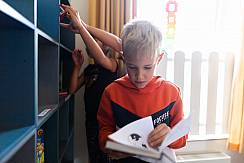 Junge schaut sich ein Buch an im Leseland