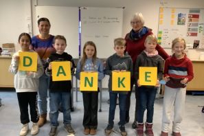 Das Bild zeigt einige Kinder, die mit Plakaten das Wort Danke bilden und zwei Mitarbeiterinnen des Kinder- und Jugendhospizdienstes Paderborn